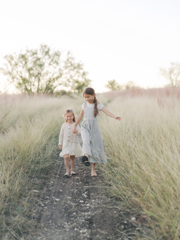 two sisters casually walking down dirt path taken by colorado springs photographer