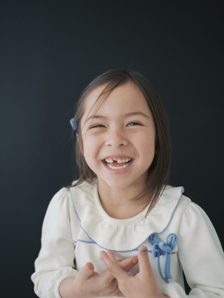 girl laughing in colorado springs studio with missing front tooth