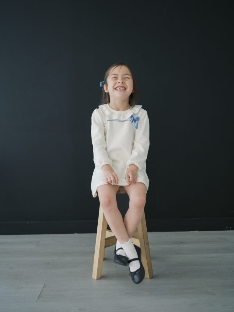 girl sitting on stool in colorado springs studio laughing 