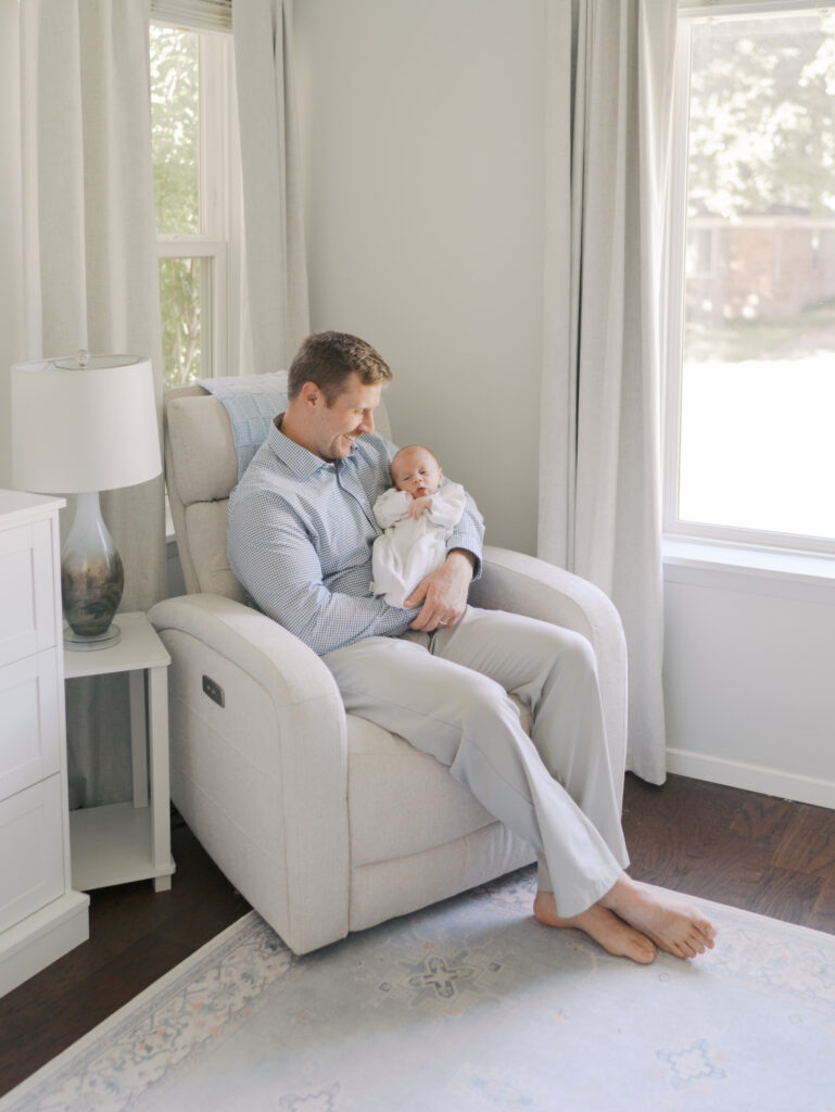 dad sitting in chair in baby nursery for Colorado Springs newborn photos