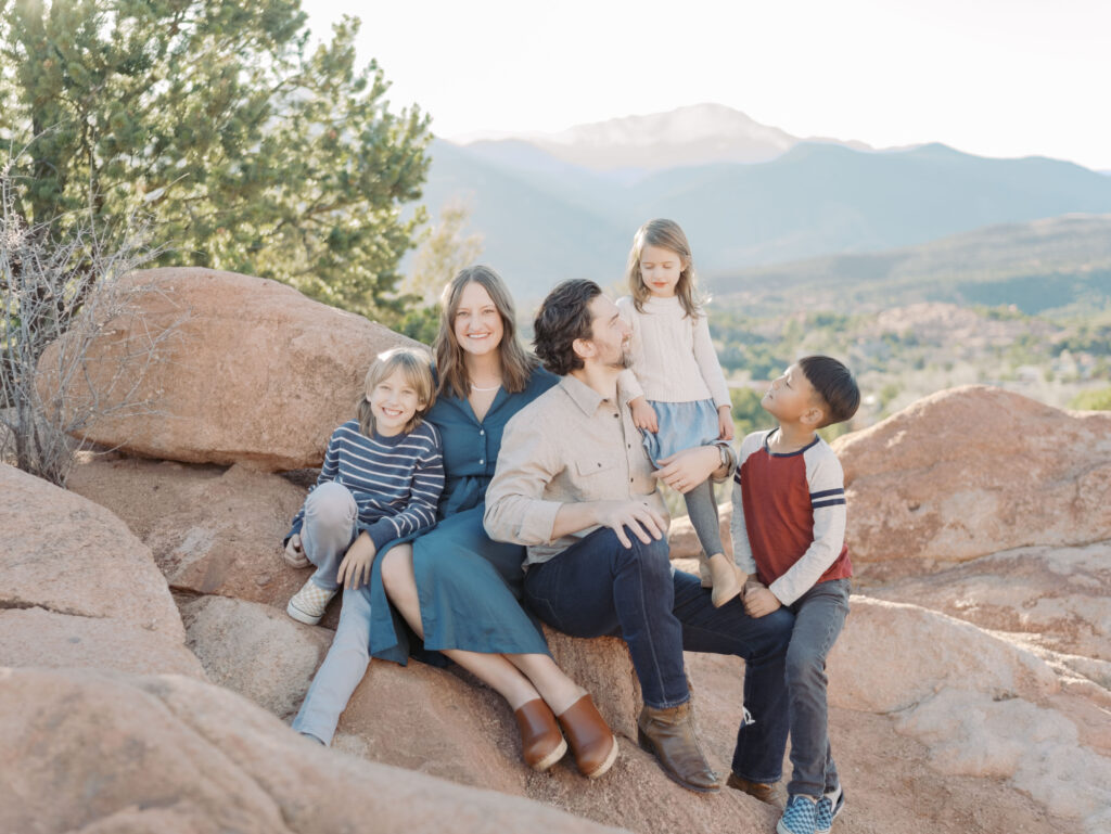 family sitting on red rock for Garden of the Gods Photos