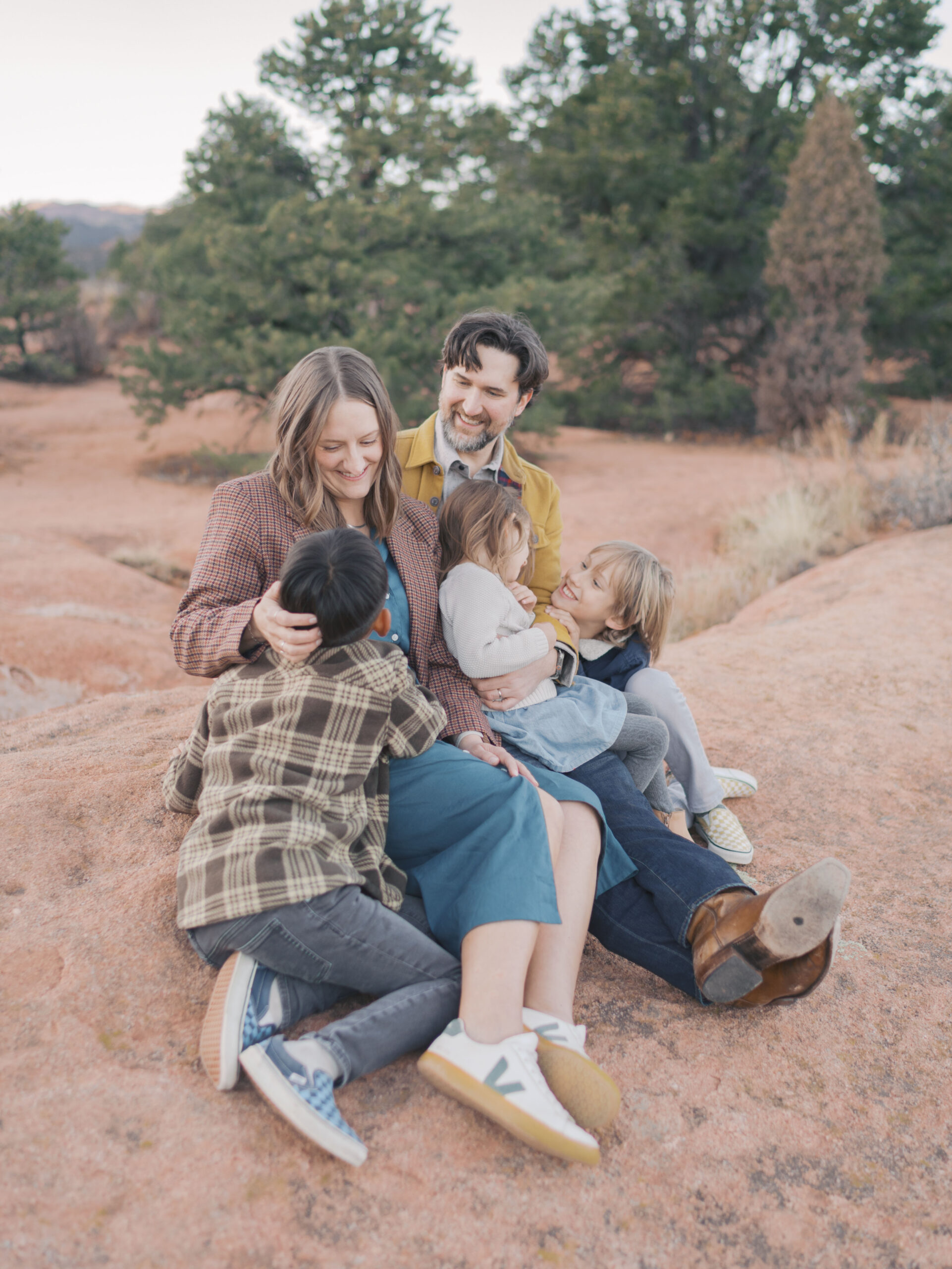 family snuggled sitting on red rock at Garden of the Gods Photos | Lauren Bounds Photography