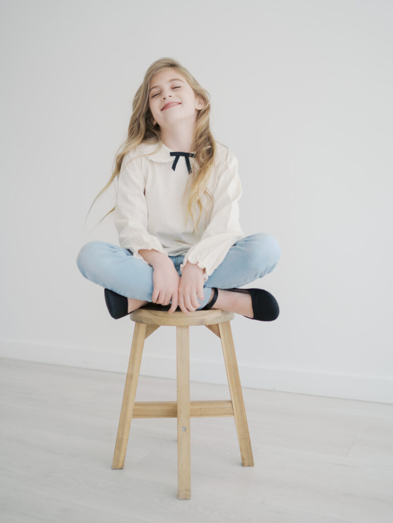 girl sitting with leg crossed on stool for Kid Mini Colorado Springs