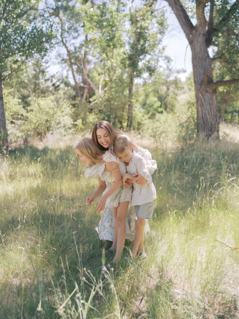 mom hugging and falling with two kids