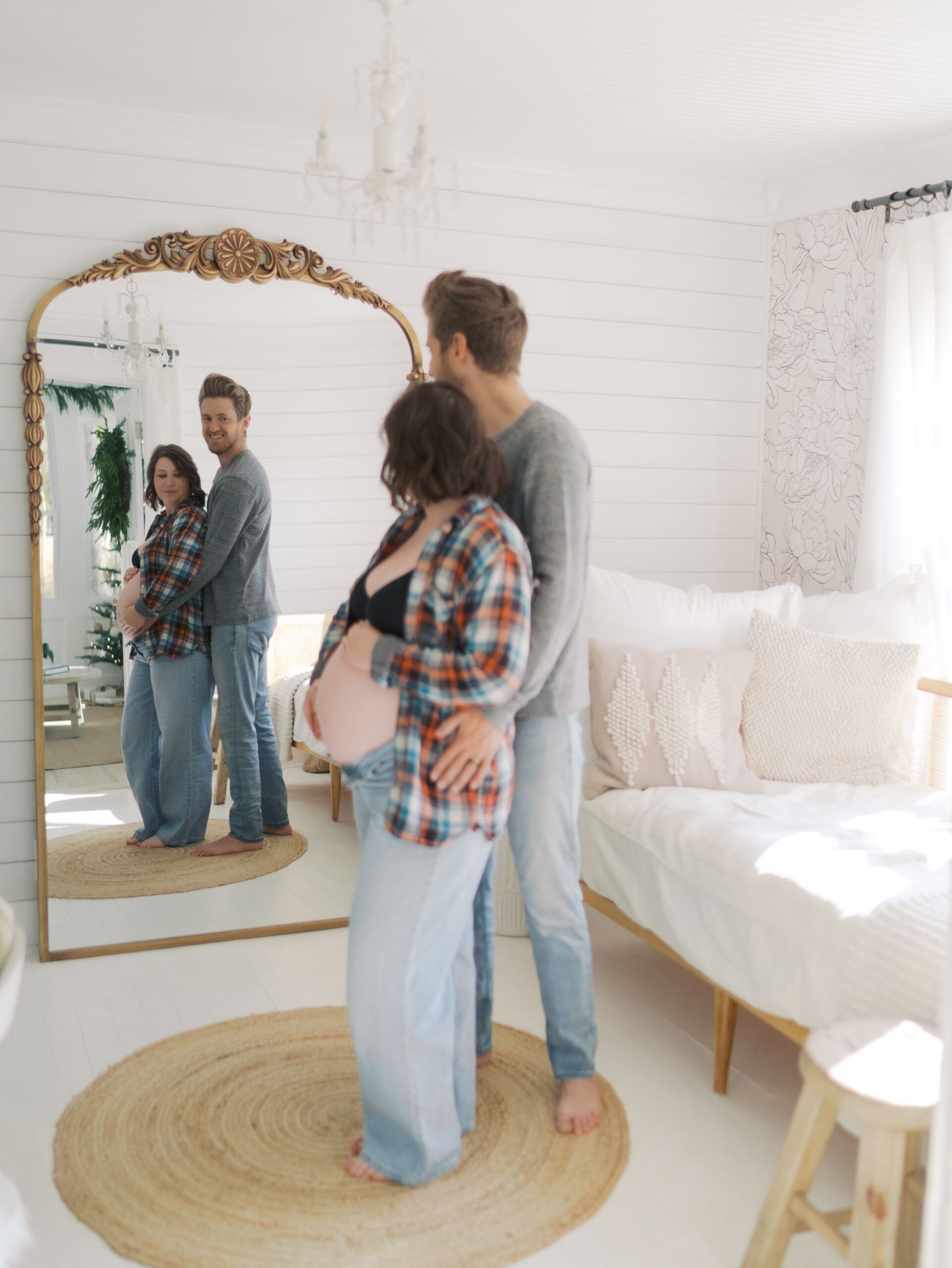 expecting couple front to back looking in floor mirror for colorado springs maternity photography