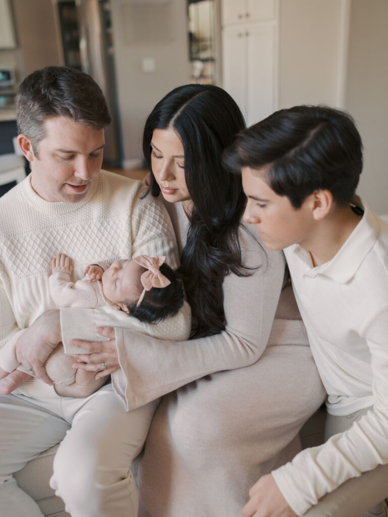 family photo with newborn baby on couch of when to book newborn photos