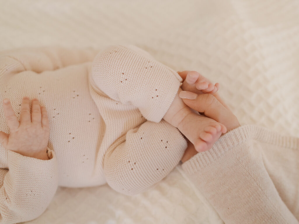 newborn feet with mom's hand