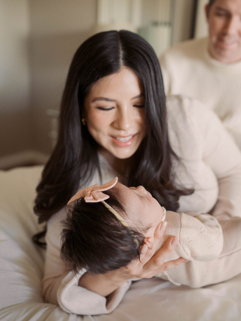 mom smiling big at newborn baby in colorado springs