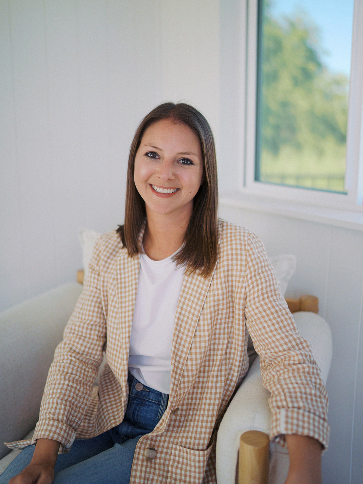Colorado Springs photographer standing against window looking at the camera