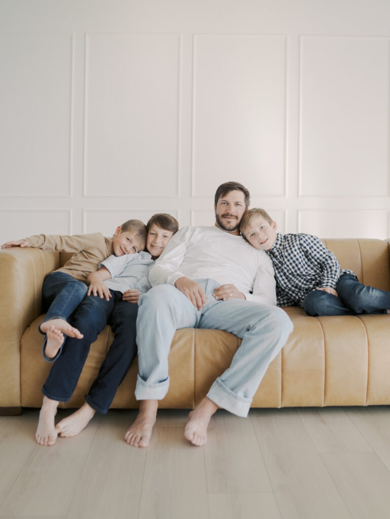 dad with three sons lounging on couch 