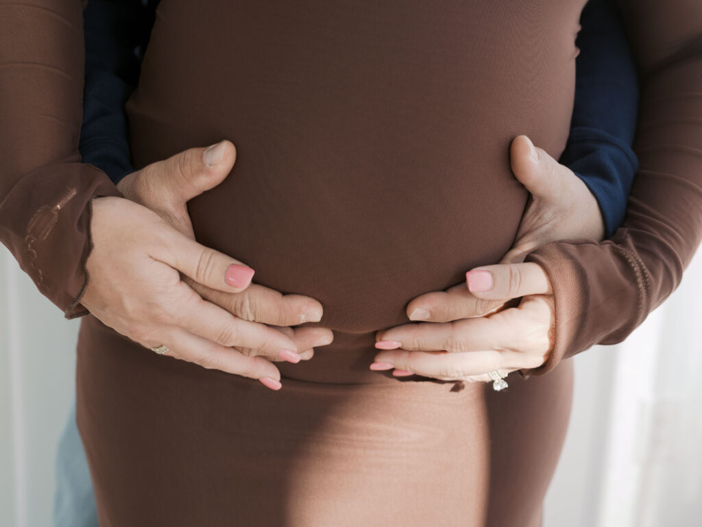 close up of expecting mom's belly with her and husband's hands on top of it for Maternity Photos in Colorado Springs