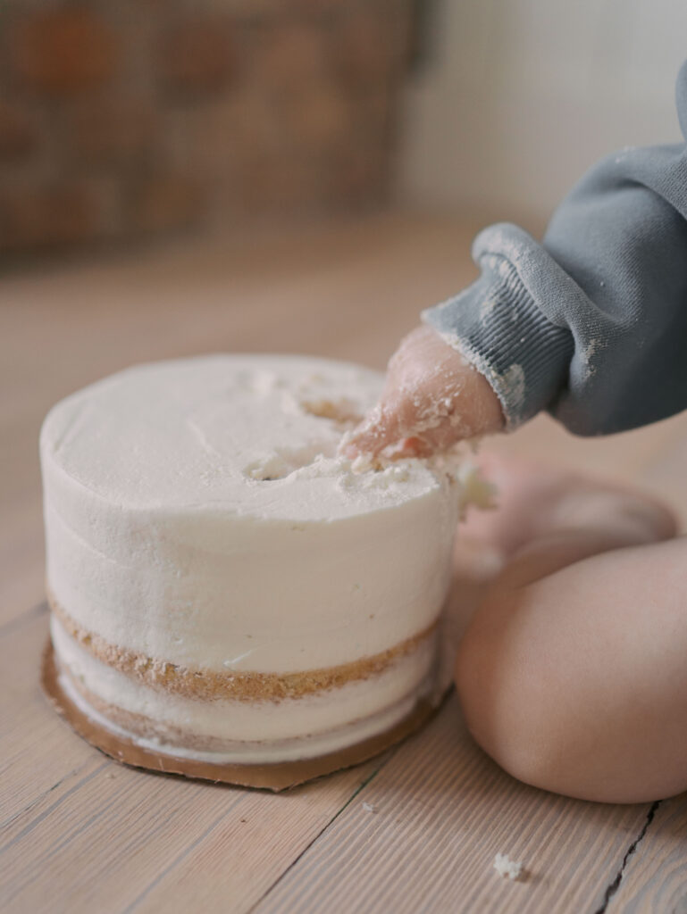 one year poking figure in smash cake for Milestone Session Colorado Springs