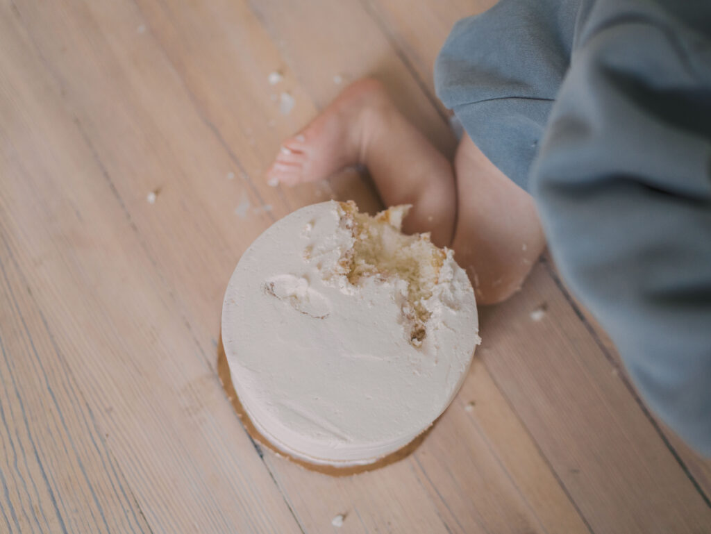 one year olds chubby leg next to smash cake for Milestone Session Colorado Springs