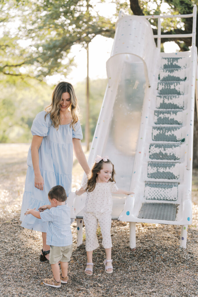 mom with two kids by slide at a park taken by Story-Driven Family Photography in Colorado Springs
