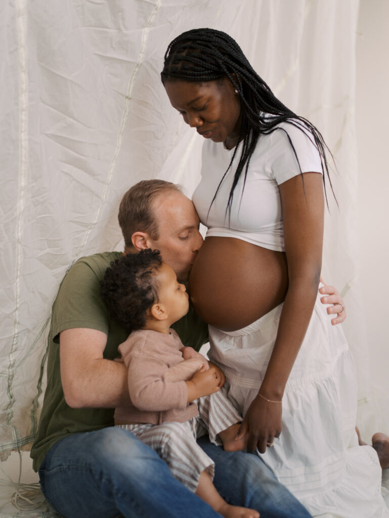 dad and boy kissing mom expecting stomach