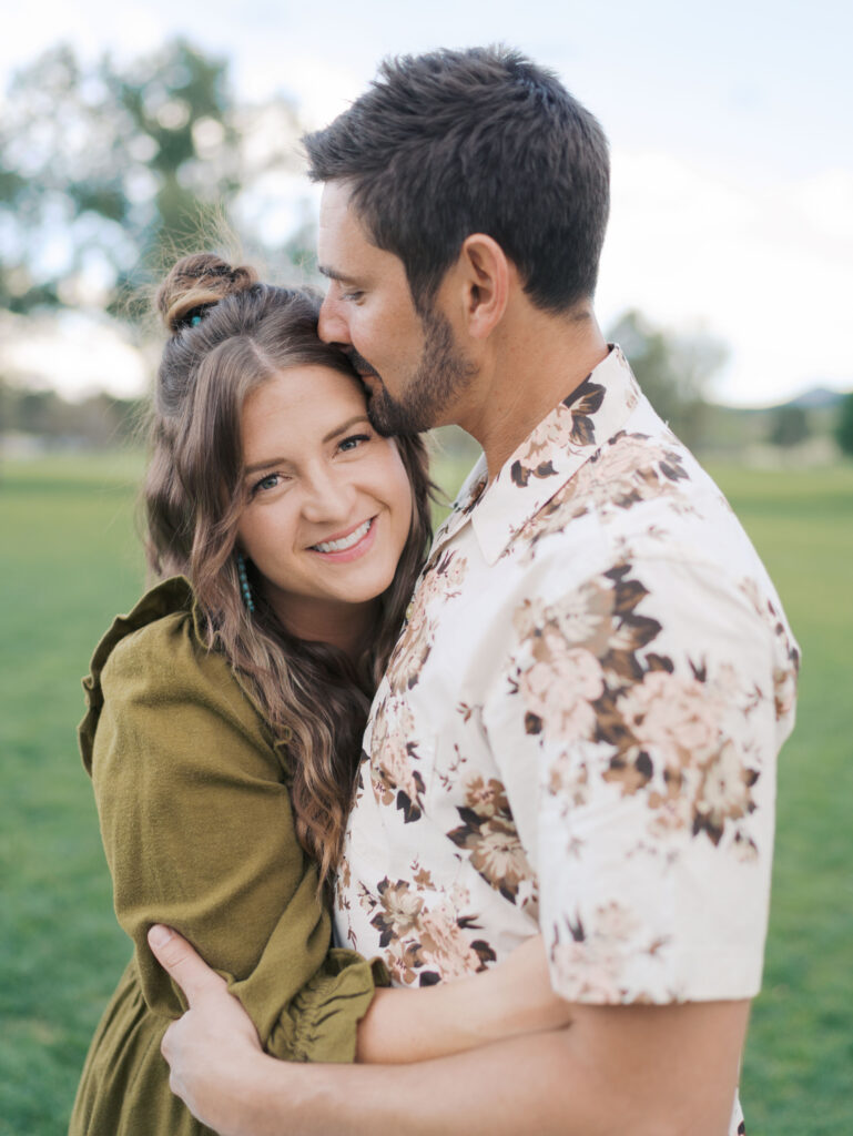 wife and husband hugging while wife looks at camera in Colorado Springs, CO