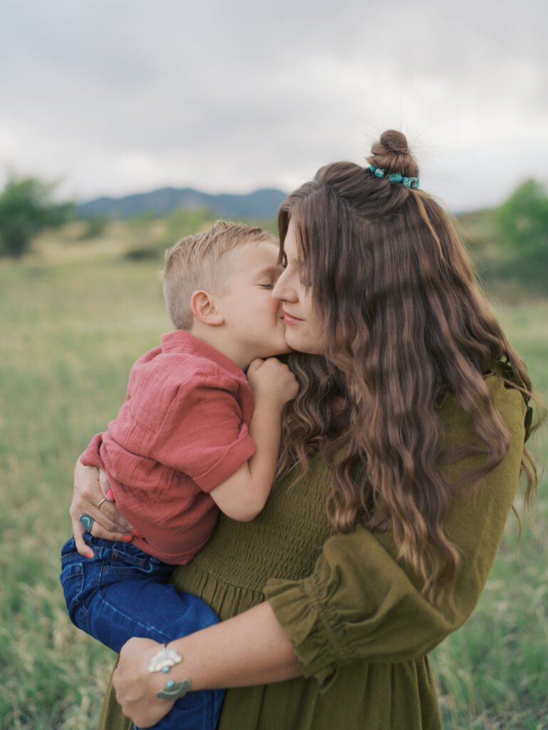 Mom and boy face to face while mom hold kid for colorado springs colorado photographers family photo session