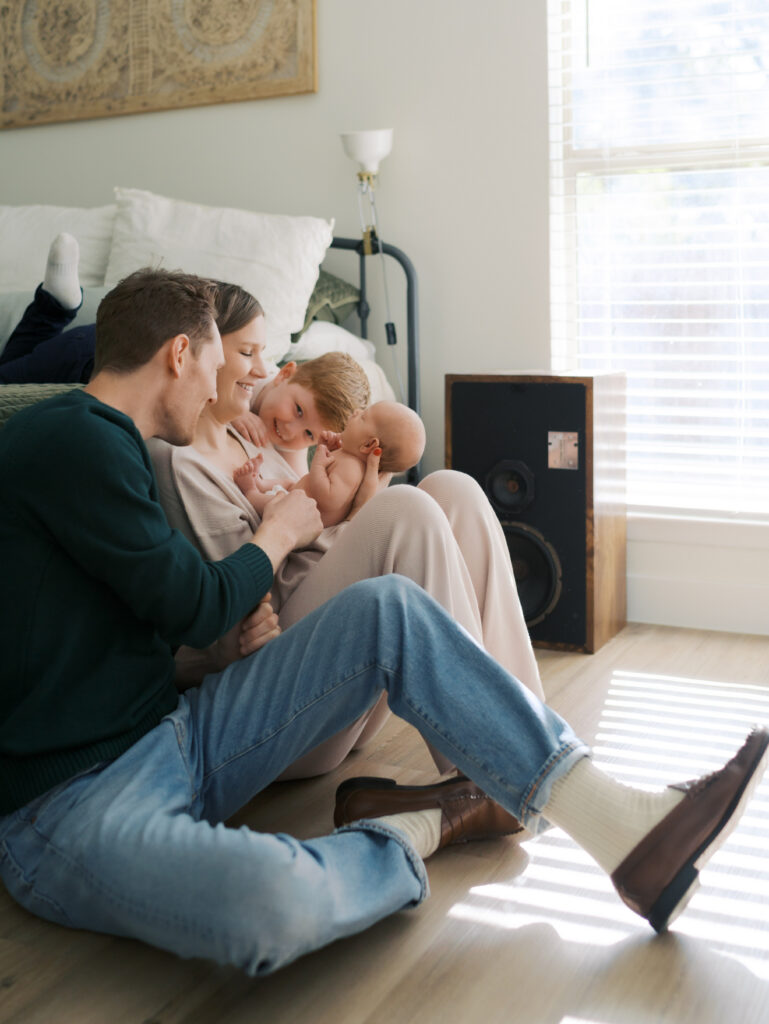 family of four with newborn, big brother looks on lovingly