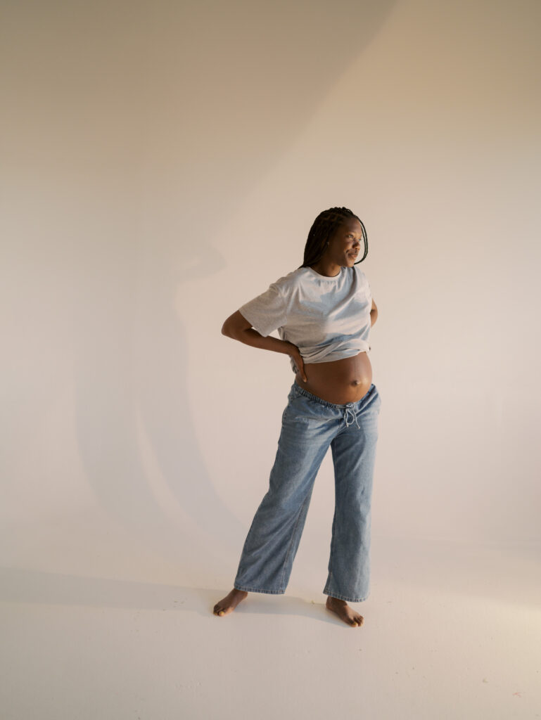 expecting mom in jeans and tshirt in studio for maternity photos with Lauren Bounds Photography